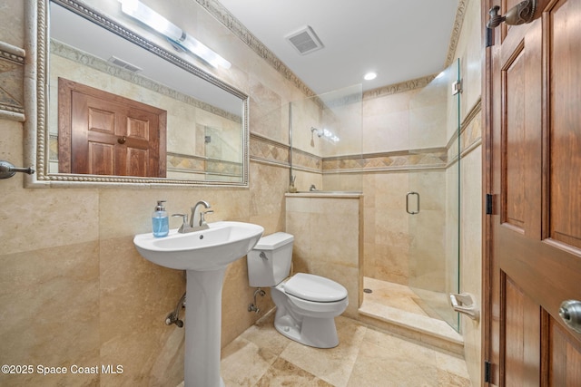 bathroom featuring an enclosed shower, sink, tile walls, and toilet