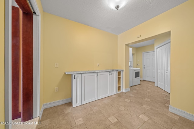 laundry room with washer / dryer and a textured ceiling