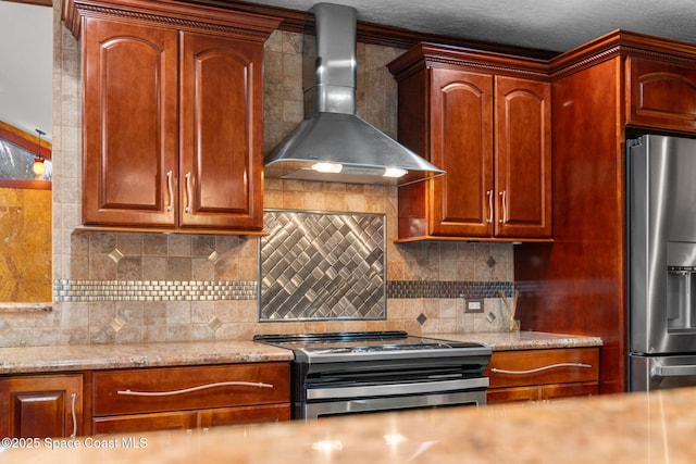 kitchen featuring light stone counters, appliances with stainless steel finishes, wall chimney exhaust hood, and decorative backsplash