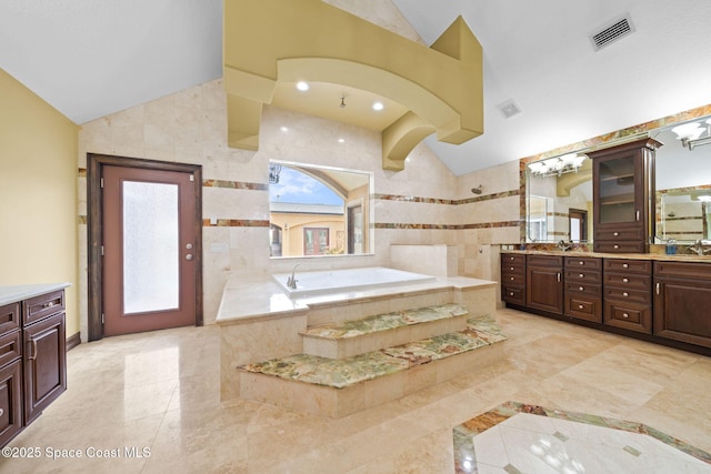 1855 Plantation Cir SE, Palm Bay, FL 32909 - full bath with lofted ceiling, a garden tub, double vanity, a walk in shower, and tile walls