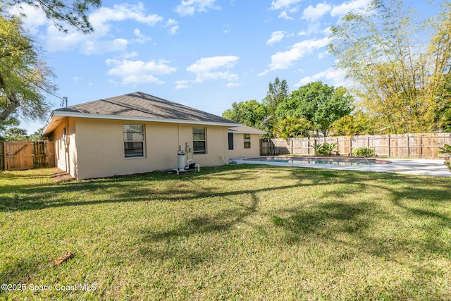 rear view of property with a fenced in pool and a lawn