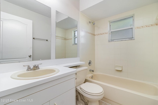 full bathroom featuring vanity, tiled shower / bath, and toilet