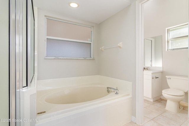 bathroom with tile patterned flooring, a relaxing tiled tub, and toilet