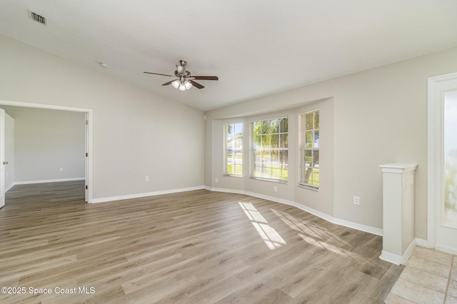 spare room featuring vaulted ceiling, ceiling fan, and light wood-type flooring