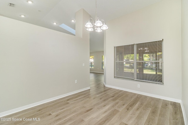 interior space featuring high vaulted ceiling, a chandelier, and light wood-type flooring