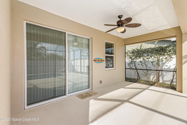 unfurnished sunroom with ceiling fan