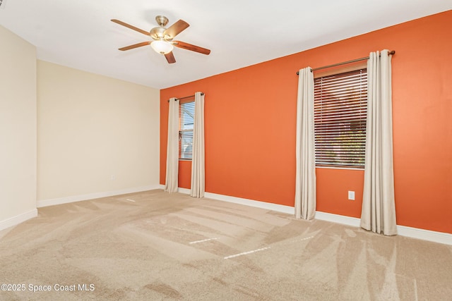 carpeted spare room featuring ceiling fan