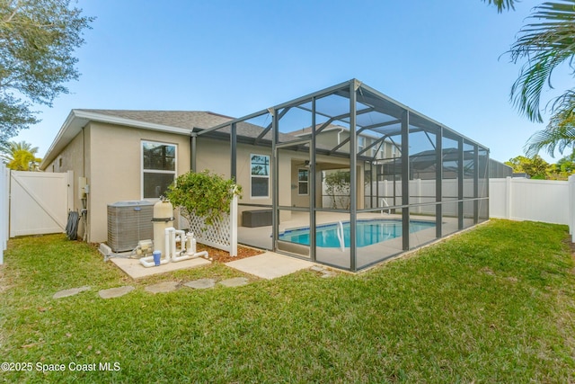 back of property featuring a fenced in pool, a lanai, a yard, and a patio area