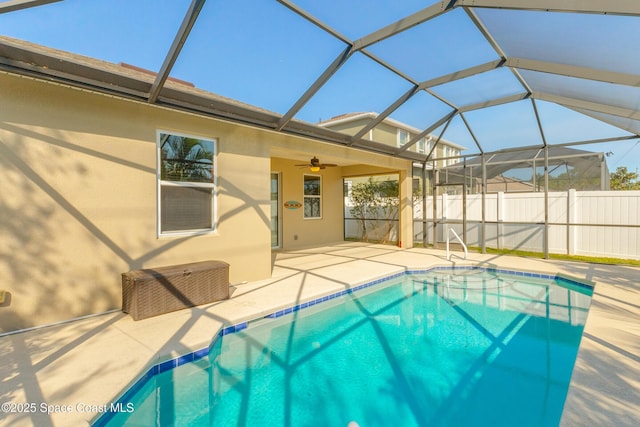 view of swimming pool with a patio, ceiling fan, and glass enclosure