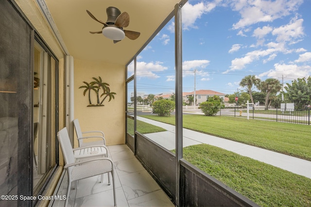 unfurnished sunroom with ceiling fan