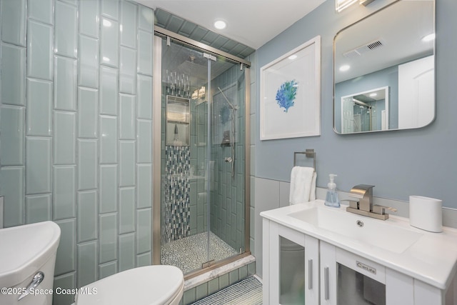 bathroom with vanity, a shower with shower door, and toilet