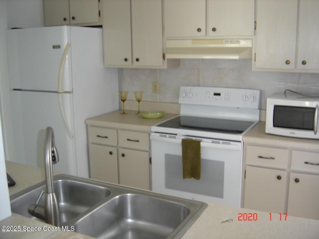 kitchen with white appliances, decorative backsplash, ventilation hood, light countertops, and a sink