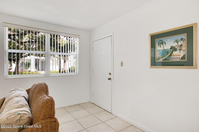 foyer entrance featuring baseboards and light tile patterned flooring