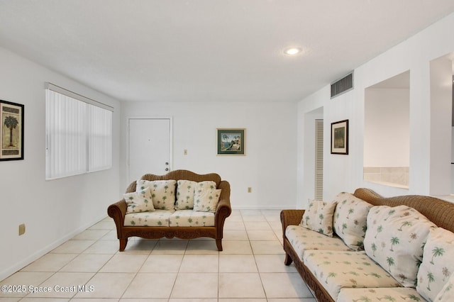 living room featuring light tile patterned floors, visible vents, and baseboards