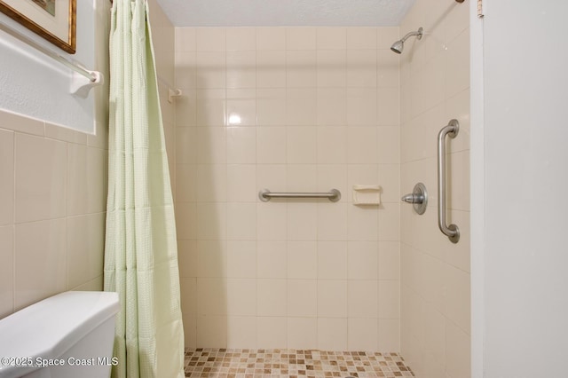 full bathroom featuring toilet, tile walls, and tiled shower