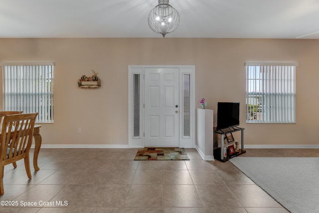 tiled foyer with an inviting chandelier