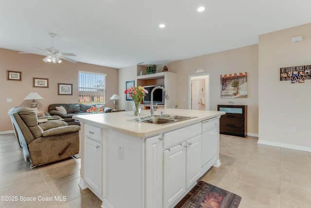 kitchen with dishwasher, sink, white cabinets, a kitchen island with sink, and light tile patterned floors