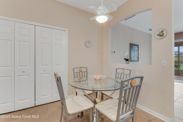 tiled dining space featuring ceiling fan