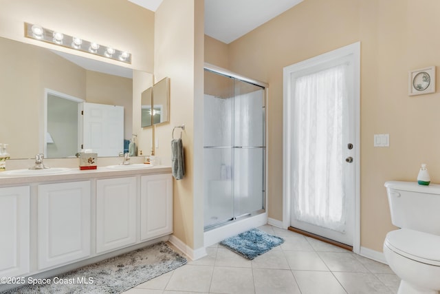 bathroom featuring vanity, toilet, tile patterned flooring, and a shower with door