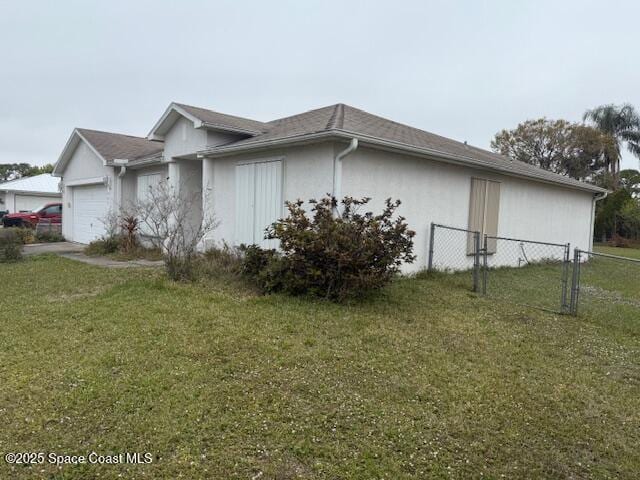 view of side of home featuring a garage and a yard