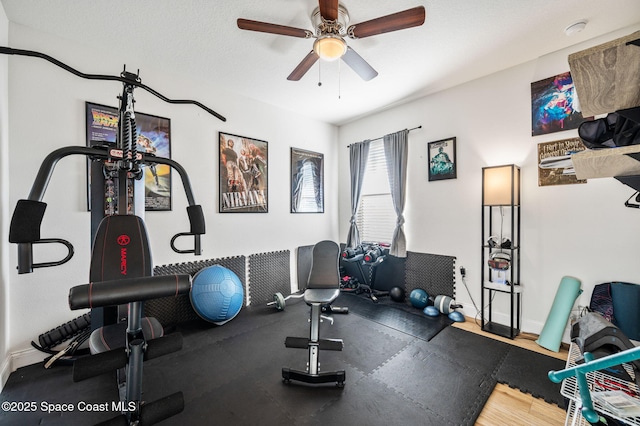 exercise area with ceiling fan and a textured ceiling