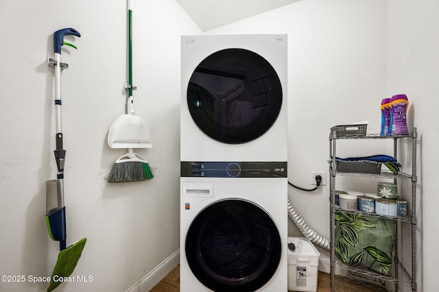 clothes washing area featuring wood-type flooring and stacked washer / drying machine