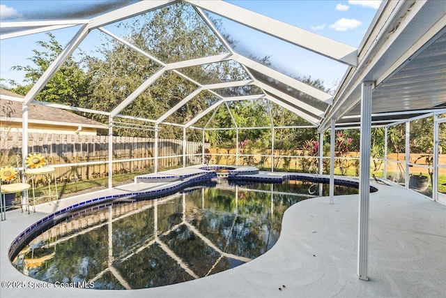 view of swimming pool with an in ground hot tub, a patio, and glass enclosure