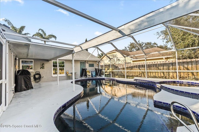 view of pool featuring a patio, an in ground hot tub, and glass enclosure