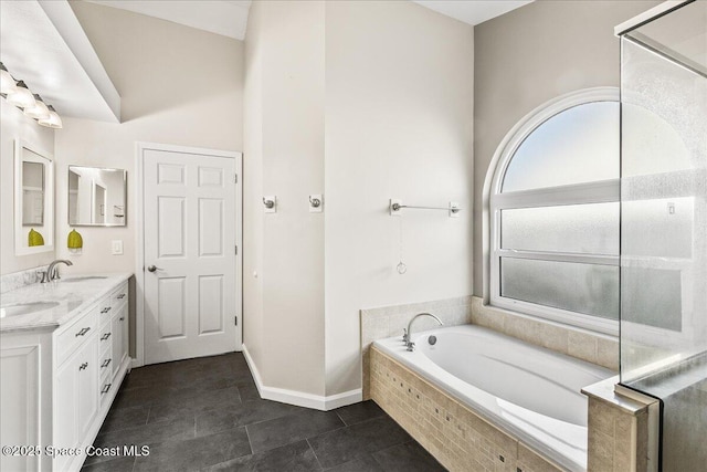 bathroom featuring vanity, tile patterned floors, and tiled bath