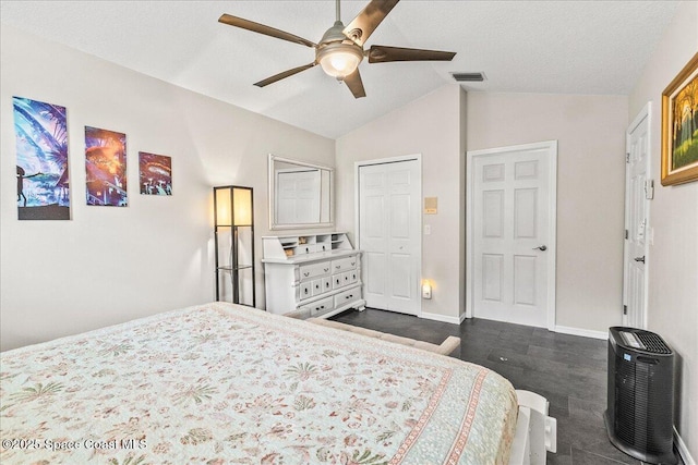 bedroom with ceiling fan, vaulted ceiling, and a textured ceiling