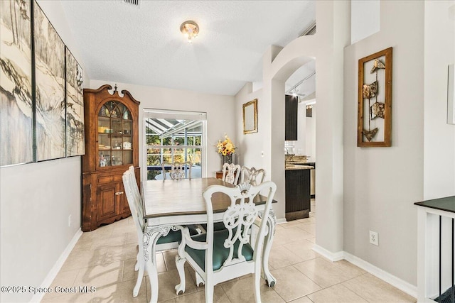 tiled dining room with a textured ceiling