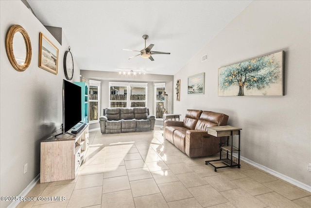 living room featuring ceiling fan, lofted ceiling, and light tile patterned floors