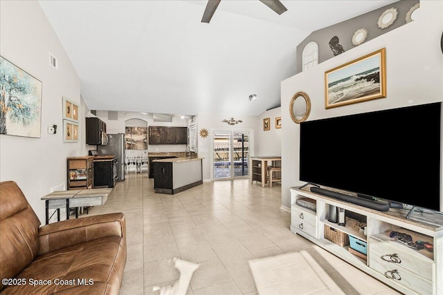 tiled living room featuring ceiling fan and vaulted ceiling