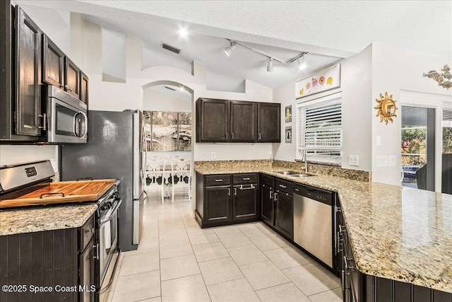 kitchen with sink, vaulted ceiling, stainless steel appliances, and light stone countertops