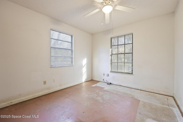 empty room with ceiling fan and a textured ceiling