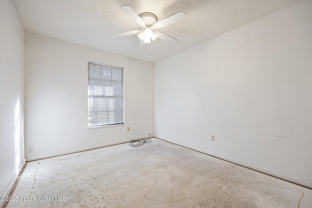 unfurnished room with ceiling fan and a textured ceiling