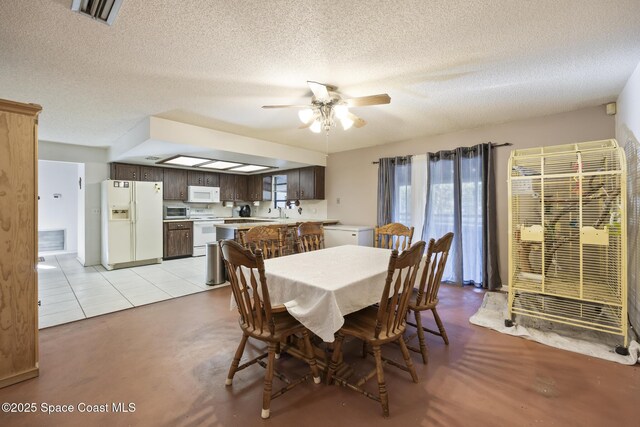 tiled dining room featuring sink, a textured ceiling, and ceiling fan