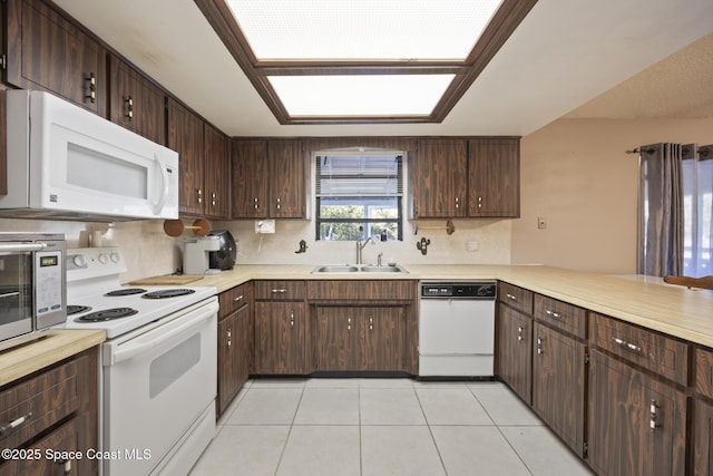 kitchen featuring sink, white appliances, dark brown cabinets, and light tile patterned flooring