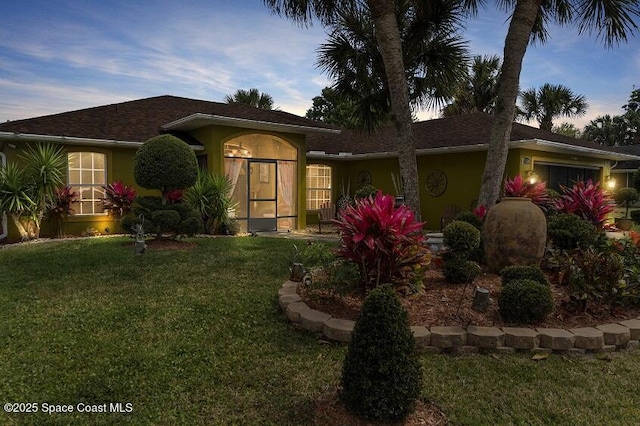 view of front of house with a yard and a garage