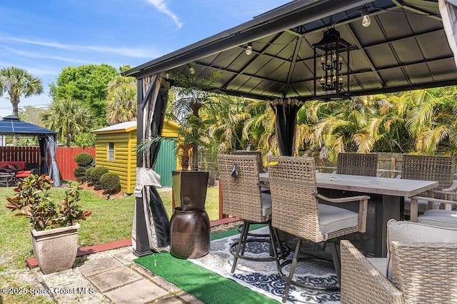 view of patio / terrace with a bar, a gazebo, and an outbuilding