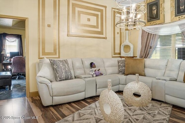 living room featuring an inviting chandelier and dark wood-type flooring