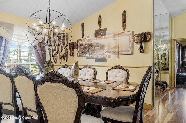 dining room featuring hardwood / wood-style flooring, vaulted ceiling, and a notable chandelier