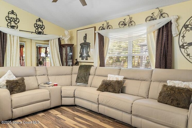 living room featuring ceiling fan, wood-type flooring, and vaulted ceiling