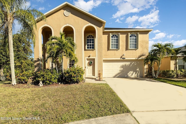 mediterranean / spanish-style home with a garage and a front yard