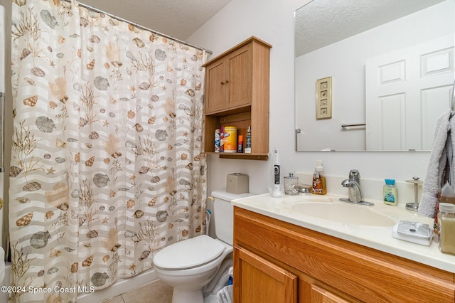 bathroom featuring tile patterned flooring, vanity, toilet, and a textured ceiling