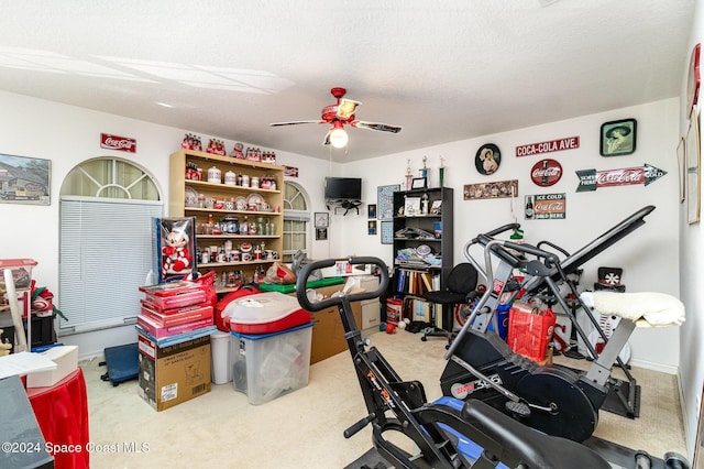 interior space featuring carpet flooring, a textured ceiling, and ceiling fan