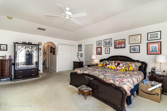 bedroom featuring light colored carpet, ceiling fan, and a closet