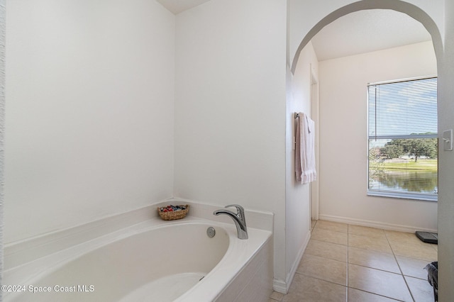 bathroom featuring tile patterned flooring and tiled tub