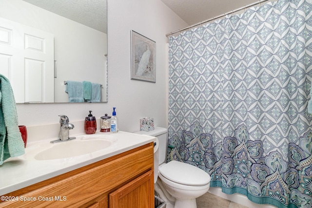 bathroom with vanity, a textured ceiling, tile patterned floors, and toilet