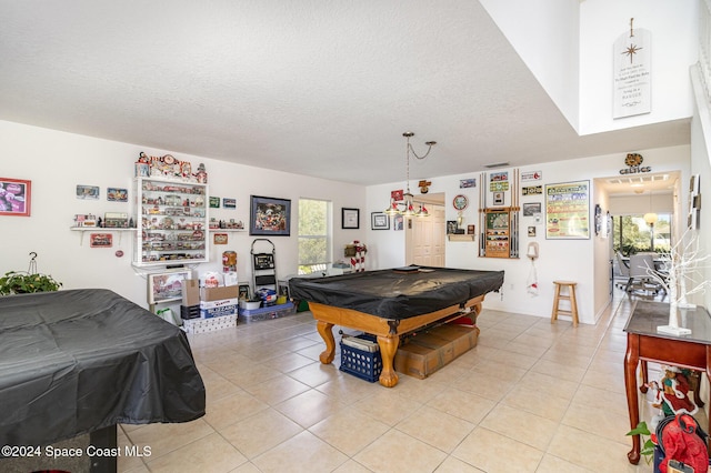 rec room featuring light tile patterned flooring, pool table, and a textured ceiling